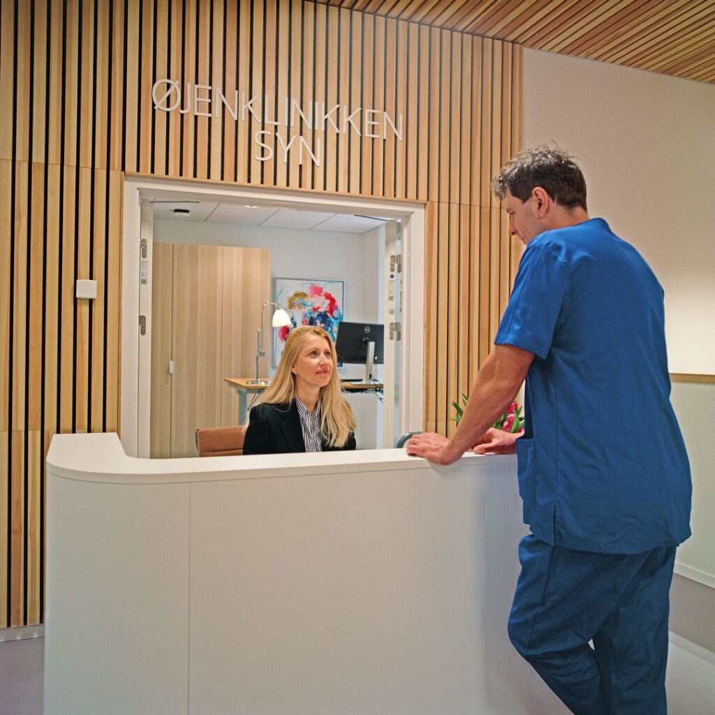Billede af en receptionist og en øjenlæge i Øjenklinikken Syn, der tilbyder professionel øjenpleje i Helsingør